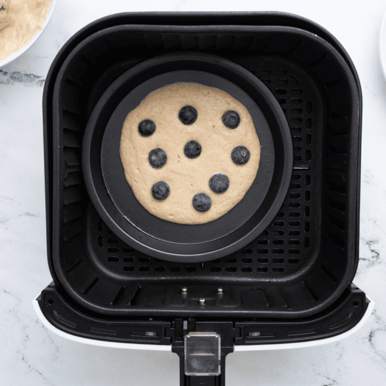 Blueberry pancake cooking in air fryer until golden and fully set