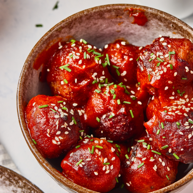 Hoisin meatballs served over rice with bok choy on a dinner plate