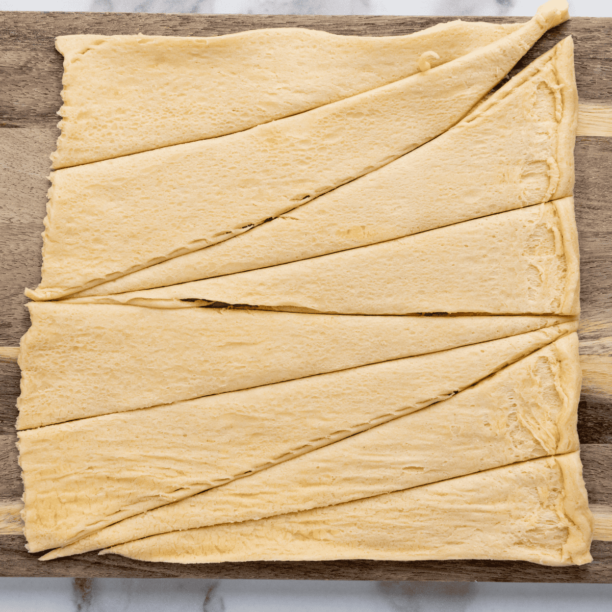Cutting the crescent dough in pieces, use a pizza cutter.