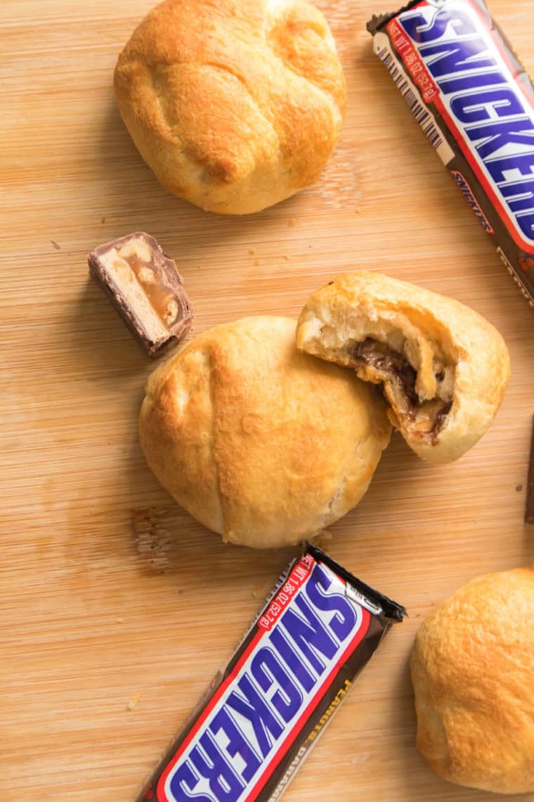 Golden air fryer Snickers Bars cut open, showing melted chocolate and caramel filling.