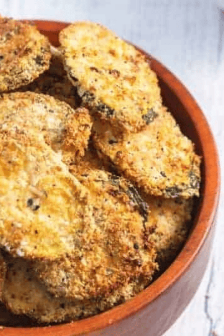 Air fryer keto zucchini chips, golden and extra crispy, served on a plate