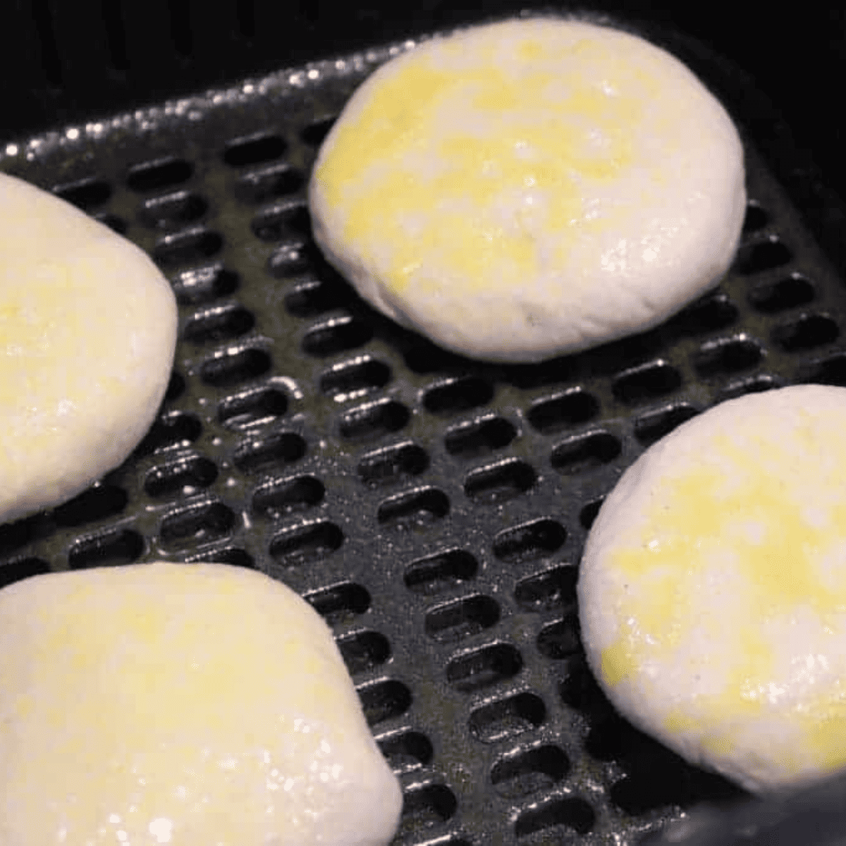Stuffed donut bundles arranged in the air fryer basket before cooking