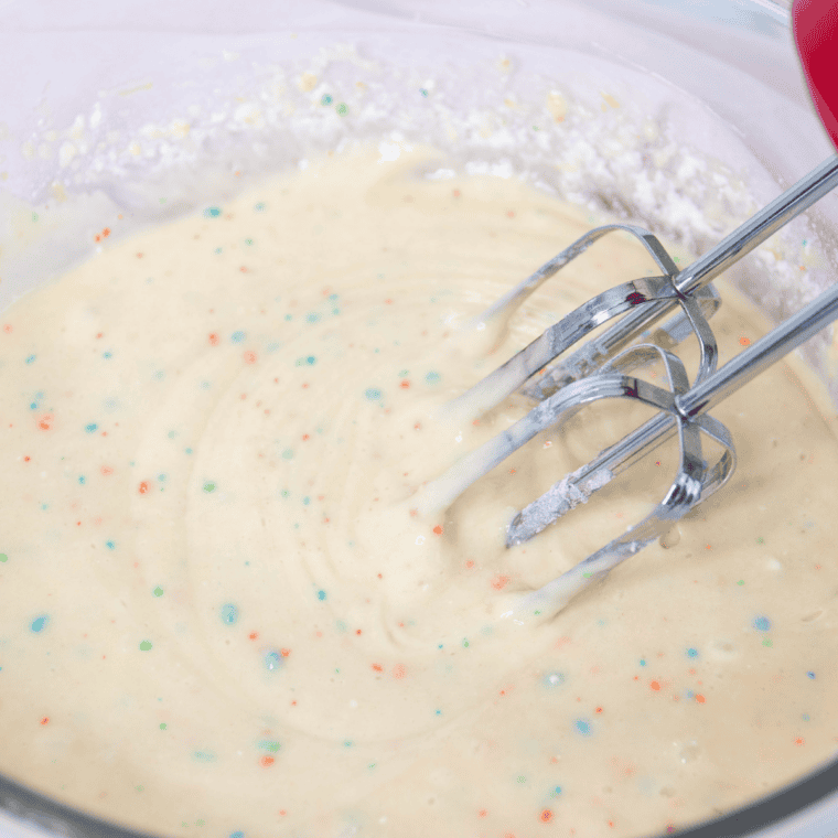 Mixing air fryer birthday cake batter with an electric hand mixer until smooth