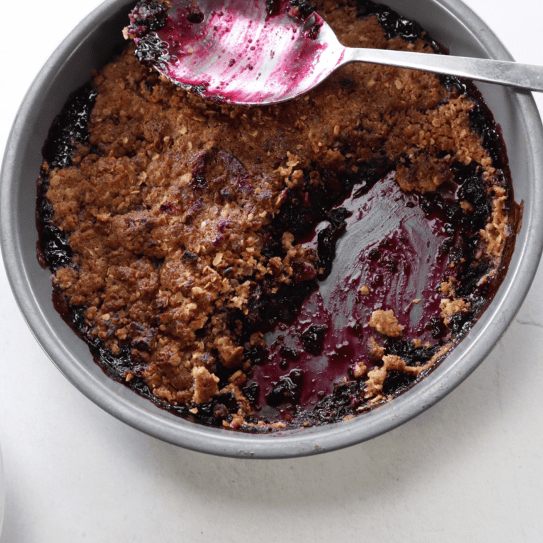 Close-up of bubbling air fryer blueberry crisp with crisp golden topping