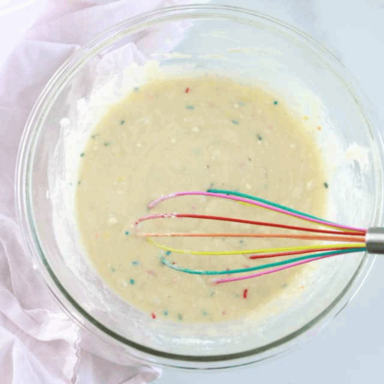 Mixing cake mix, egg, oil, and water in a large bowl to prepare donut batter.