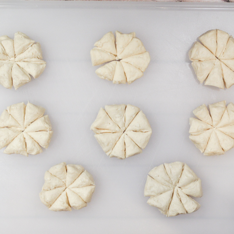 Cutting Pillsbury biscuits into quarters for pizza casserole.