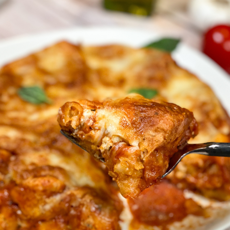 Air fryer pepperoni pizza casserole topped with melted cheese in a white dish.