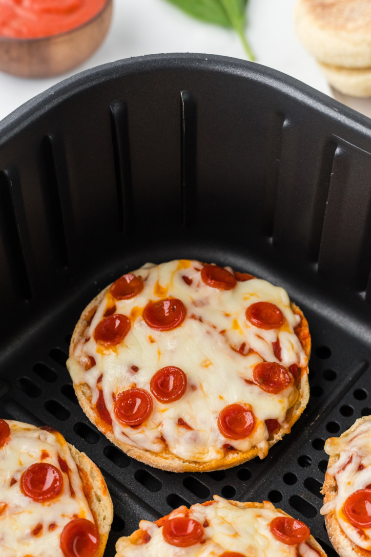Pinterest pin showing four air fryer English muffin pizzas with text overlay reading "Easy Air Fryer English Muffin Pizzas — 10 Minutes"