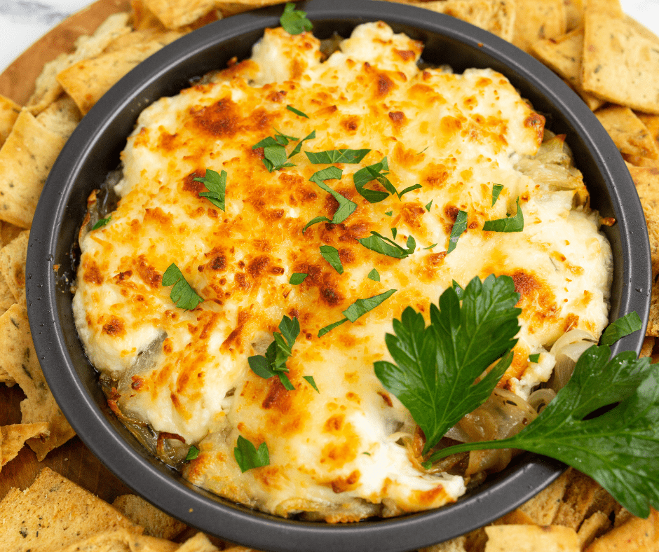 Finished Air Fryer French Onion Dip served in a bowl with vegetable sticks on the side.