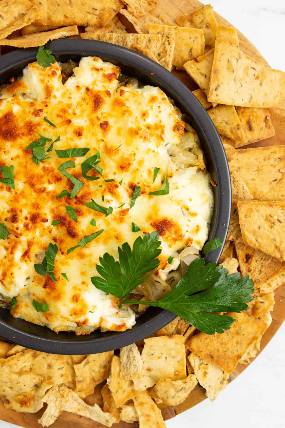 "Finished Air Fryer French Onion Dip served in a bowl with vegetable sticks on the side."