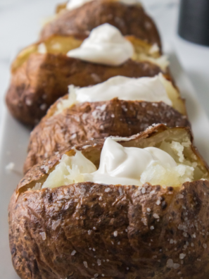 Air fryer jacket potato split open with butter melting into the fluffy middle