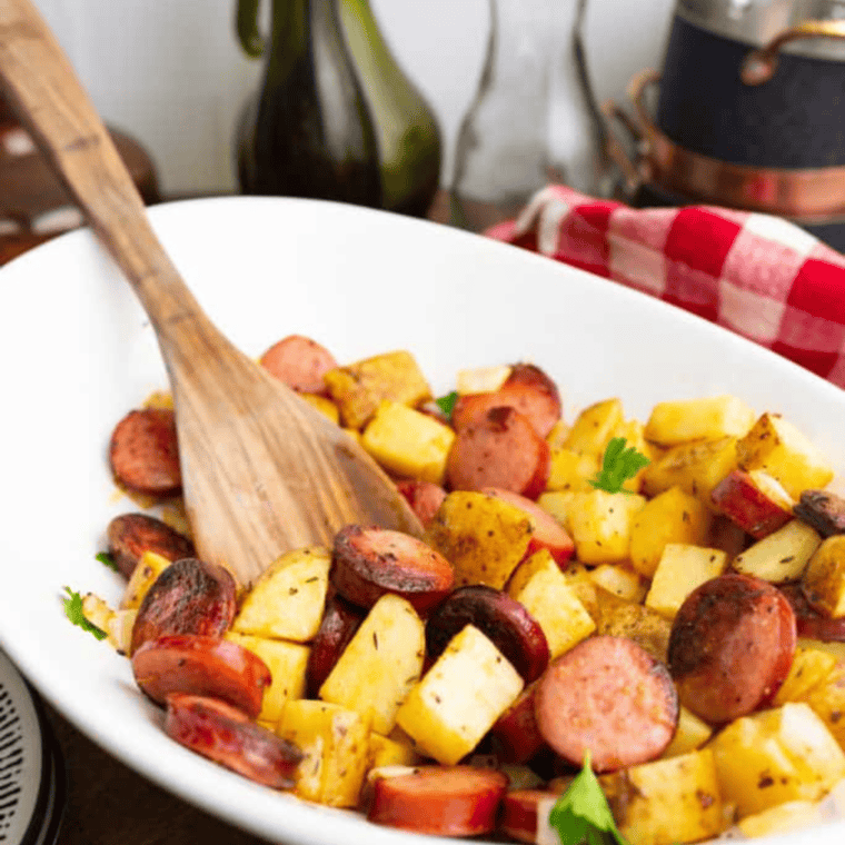 A bowl filled with crispy air fryer kielbasa and potatoes, ready to serve.