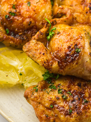 Crispy air fryer ranch chicken thighs served on a plate with fresh herbs.