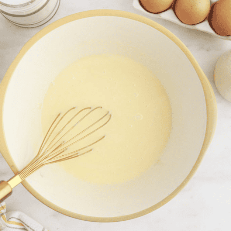 Dry ingredients being mixed in a large bowl for cornbread, including cornmeal, flour, salt, baking soda, and baking powder, before adding buttermilk, milk, and egg