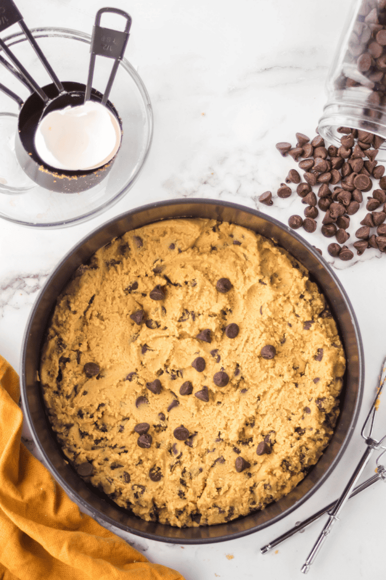 Folding chocolate chips evenly into cookie dough to distribute throughout.