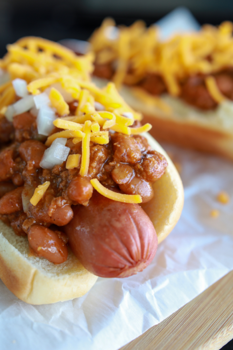 Hot dogs cooking in a Ninja air fryer basket with crispy golden edges and juicy centers, ready to serve in buns.