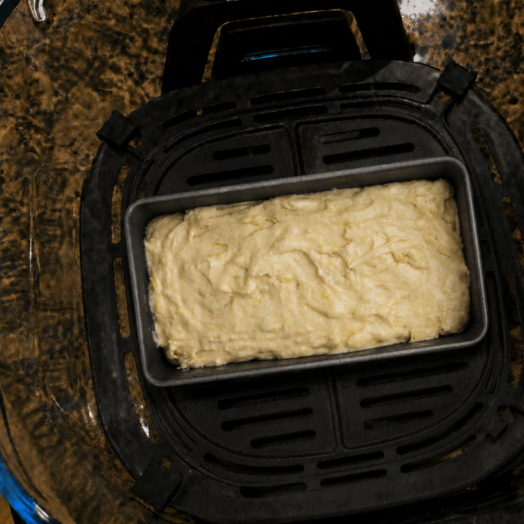 Banana bread batter in a small loaf pan placed inside the Ninja Crispi container