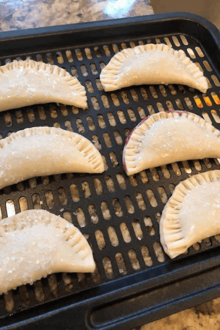 Golden air fryer blueberry hand pies with flaky crust, juicy blueberry filling, and vanilla glaze