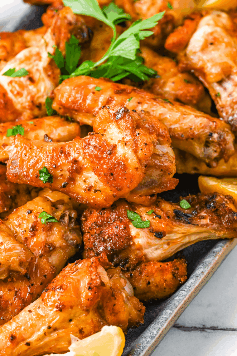Plate of Air Fryer Chinese Salt and Pepper Chicken Wings with fresh herbs.