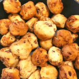 Air Fryer Cinnamon Roll Bubble Bites, golden brown and drizzled with glaze on a plate.