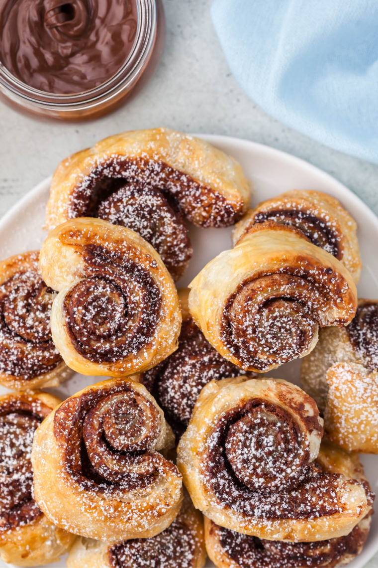 Air fryer Nutella puff pastry bites with a molten chocolate hazelnut center, broken open to show the flaky layers