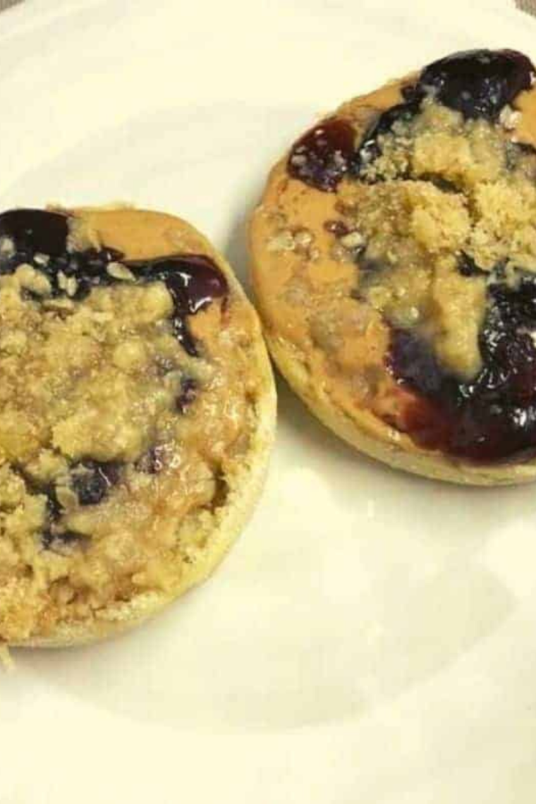 Toasted English muffins topped with peanut butter, jelly, and golden streusel crumble from the air fryer.