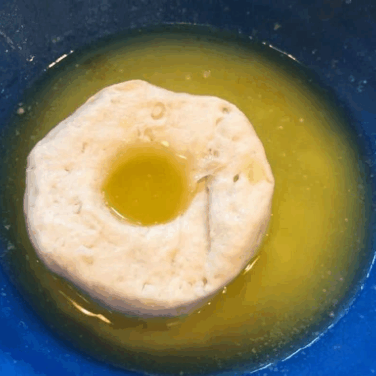 Dipping raw biscuit dough in melted butter before air frying so the donuts don't taste like biscuits