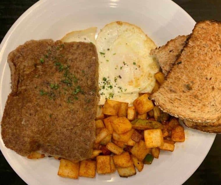 What Is Scrapple?
Scrapple is a traditional American food product that originated in the Pennsylvania, Dutch, and Mid-Atlantic regions of the United States. It is often described as a type of pork-based meatloaf or sausage patty. Scrapple is typically made from pork scraps, such as the head, heart, liver, and other leftover parts, combined with cornmeal and various spices like sage, thyme, and black pepper. The mush of pork scraps is then formed into a loaf, cooked until solidified and sliced into individual servings. Scrapple is known for its crispy exterior and soft, savory interior and is often pan-fried until golden brown before serving. It's a popular breakfast dish in some areas and is enjoyed with condiments like ketchup or maple syrup. While it may not be to everyone's taste due to its unique ingredients, it holds a special place in the culinary traditions of the regions where it's popular.
Can You Air Fry Scrapple?
Yes, you can air fry scrapple to achieve a crispy and delicious result. Air frying scrapple is a convenient way to enjoy this regional delicacy with less mess and a perfectly crispy texture.
Why Air Fry Scrapple?
Crispy Texture: Air frying allows you to achieve a crispy scrapple exterior without excessive oil. The hot circulating air in the air fryer helps create that desirable crunch.
Healthier Option: By air frying scrapple, you can significantly reduce the amount of oil used compared to traditional frying methods. It's a healthier alternative for those who enjoy scrapple without excess grease.
Convenience: Air fryers are known for their convenience. They preheat quickly, and cooking is generally faster than an oven or stovetop. This makes air frying scrapple a time-saving option for busy mornings.
Reduced Mess: Air frying minimizes splattering and eliminates the need for excessive cleanup since there's no oil bubbling in a pan. This is especially helpful when dealing with foods that release grease when cooked.
Even Cooking: Air fryers distribute heat evenly, ensuring that both sides of the scrapple slices are cooked uniformly. You won't need to worry about flipping them constantly to prevent burning or uneven cooking.
Ingredients Needed For Air Fried Scrapple
With these essential ingredients and the magic of air frying, you can enjoy a scrumptious plate of scrapple with a perfect crispy texture.
Remember the step-by-step directions and detailed ingredient list are below in the printable recipe card, at the bottom of the post, at the bottom of the post, and the nutritional information.
Scrapple Slices: The star of the dish, scrapple is a savory, pork-based breakfast meat typically formed into slices.
Cooking Spray: A light coating of cooking spray is used to prevent sticking and help achieve that crispy exterior.
How To Cook Scrapple In The Air Fryer
Cooking scrapple has never been easier than in the air fryer; follow this step-by-step guide.
Preheat Your Air Fryer: Preheat your air fryer to 375 degrees F (190°C) for about 3-5 minutes.
Slice the Scrapple: Cut the Scrapple into slices of your desired thickness. Generally, slices around 1/4 to 1/2 inch thick work well; you can also cut the scrapple into scrapple fries.
Arrange in the Air Fryer Basket: Place the scrapple slices in a single layer in the air fryer basket. Make sure they aren't touching to allow for even cooking.
Air Fry: Cook the scrapple at 375°F (190°C) at a cook time of 8-10 minutes. You can flip the slices halfway through the cooking time to ensure both sides get crispy.
Check for Doneness: When done, the scrapple should be golden brown and crispy. Cooking times may vary slightly depending on your air fryer model, so keep an eye on it during the last few minutes.
Serve: Once the scrapple is cooked to your desired crispiness, remove it from the air fryer and let it cool for a minute or two. Then, serve it hot with your favorite breakfast sides, such as eggs, toast, or pancakes.
Air frying scrapple is a fantastic way to achieve that perfect crispy texture without excess oil. Enjoy your scrumptious breakfast!
Pro Tips For Making Crispy Scrapple In The Air Fryer
Here are some pro tips to ensure your air-fried scrapple turns out delicious:
Preheat the Air Fryer: Preheating the air fryer ensures that the scrapple will start cooking immediately, giving it a crispy texture.
Don't Overcrowd: Make sure not to overcrowd the air fryer basket. Place the scrapple slices in a single layer with some space between them for even cooking.
Spray with Cooking Oil: Lightly spray or brush the scrapple slices with cooking oil before placing them in the air fryer. This helps enhance the crispiness.
Flip Halfway Through: Flip the scrapple slices halfway through the cooking time to achieve even browning and crispness on both sides.
Check for Doneness: Keep an eye on the scrapple during the last few minutes of cooking. Cooking times may vary depending on the thickness of the slices and your air fryer model. Please remove it from the air fryer when it reaches your desired level of crispiness.
Serve with Condiments: Scrapple pairs well with ketchup, maple syrup, or apple butter. Consider offering these on the side for dipping or drizzling.
Experiment with Seasonings: Before air-frying, you can season the scrapple slices with herbs, spices, or seasoning blends for added flavor.
Following these tips, you can enjoy perfectly crispy air-fried scrapple for a delightful breakfast or brunch.
What is scrapple made of? Scrapple is typically made from pork, specifically the scraps and trimmings of the pig, such as the head, heart, liver, and other organs. These ingredients are combined with cornmeal and spices.
Is scrapple the same as sausage or bacon? No, scrapple is a distinct pork product with unique flavor and texture. While sausages and bacon are also made from pork, they have different ingredients and preparation methods.
How is scrapple traditionally served? Scrapple is often sliced and fried until crispy, then served as a breakfast side dish. Eggs, toast can accompany it, or a breakfast sandwich.
Can you air fry scrapple? Yes, you can air fry scrapple. Cooking scrapple in an air fryer can yield crispy results without adding excess oil.
What spices are typically used in scrapple? Spices used in scrapple can vary, but common seasonings include sage, thyme, black pepper, and sometimes red pepper flakes. The specific spice blend may vary by region or personal preference.
Can you freeze scrapple? Yes, scrapple can be frozen for later use. Slice it into portions, wrap each portion tightly in plastic or aluminum foil, and store them in an airtight container or freezer bag.
Is Scrapple gluten-free? Traditional scrapple recipes contain cornmeal, which is a gluten-containing ingredient. However, some manufacturers produce gluten-free scrapple using alternative grains or flour.
How do you reheat leftover scrapple? To reheat leftover scrapple, you can use methods like frying it in a skillet, baking it in the oven, or air frying until heated and crispy.
Where can I buy scrapple? You can typically find scrapple at your local grocery store, butcher shops, farmers' markets, online retailers, specialty food stores, and some restaurants, especially in regions where scrapple is popular.
What are some scrapple recipe ideas? Scrapple can be used in various recipes, including breakfast sandwiches, scrapple and eggs, scrapple sliders, and even scrapple stuffing for poul
More Air Fryer Recipes