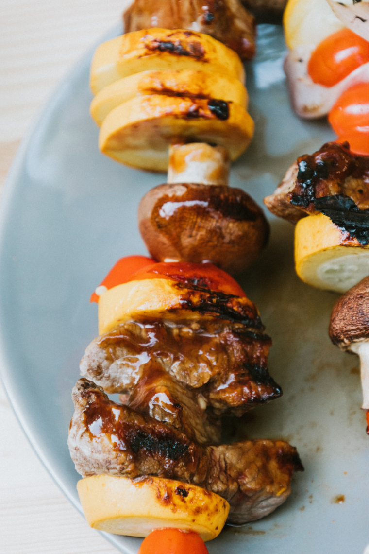 Cooked beef kabobs with charred steak, bell peppers, and onions on skewers
