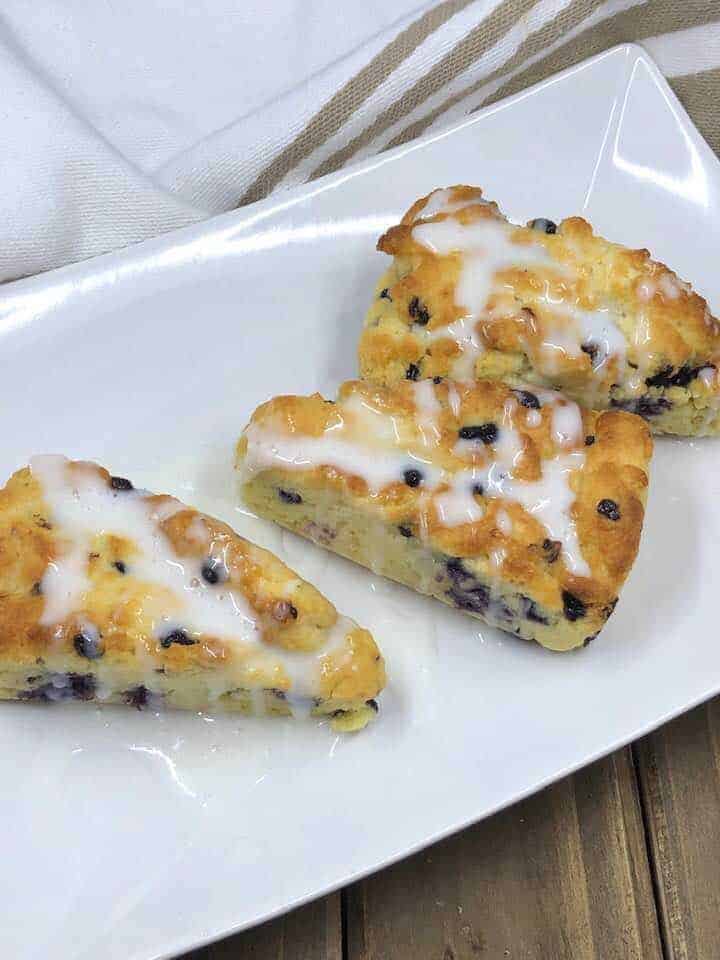 Freshly baked blueberry scones with golden-brown tops cooling on a wire rack