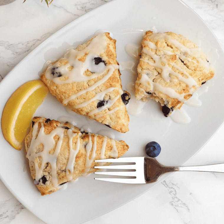 A flaky scone split open to show juicy blueberries baked inside