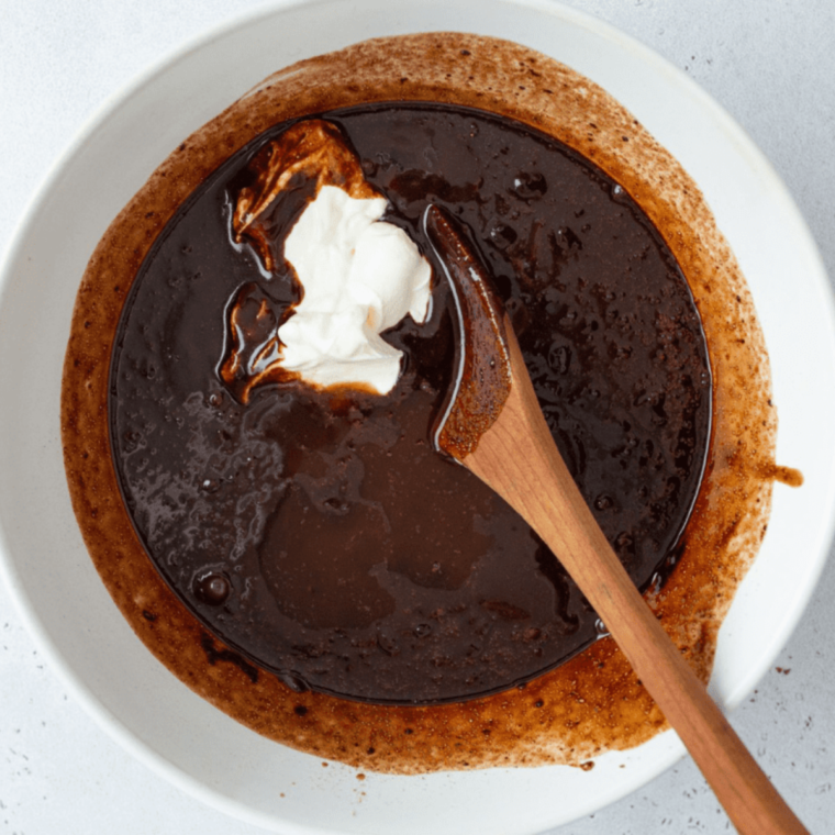 Gradually mix the dry ingredients into the wet mixture to form dough, then fold in mini chocolate chips and chocolate chunks evenly.
