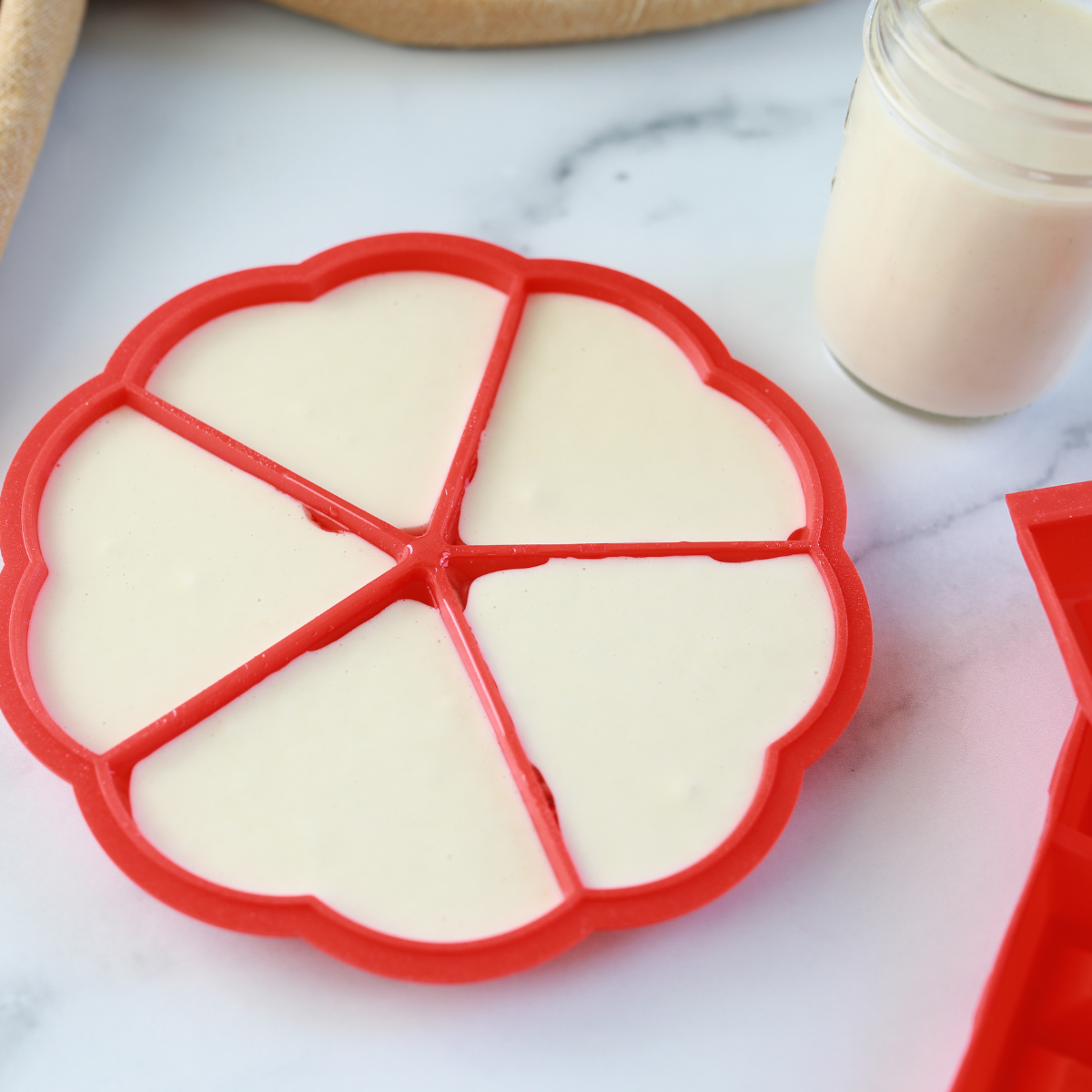 Filling silicone molds with homemade waffle batter.