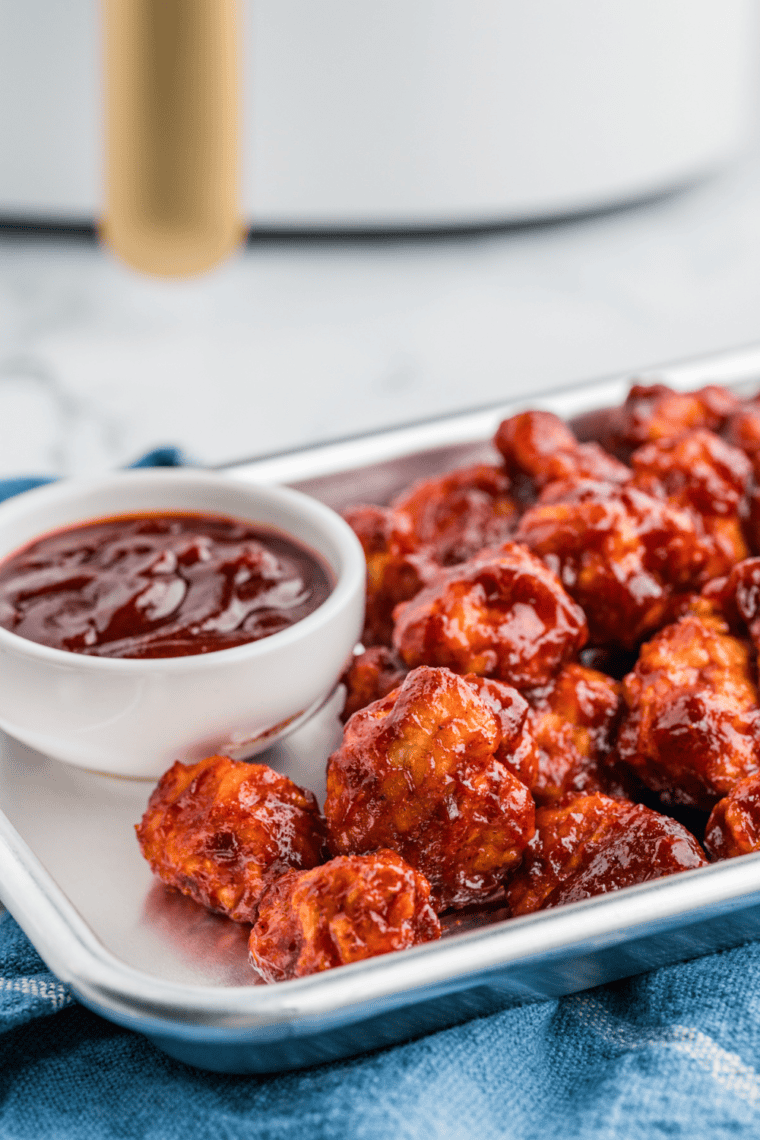 Golden, crispy Air Fryer Honey BBQ Boneless Wings with a glossy coating of BBQ sauce on a plate.