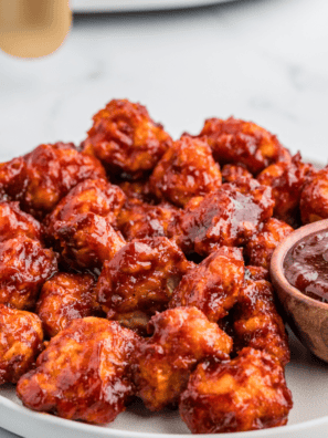 Crispy Air Fryer Honey BBQ Boneless Wings coated in sauce and served on a plate with dipping sauce.