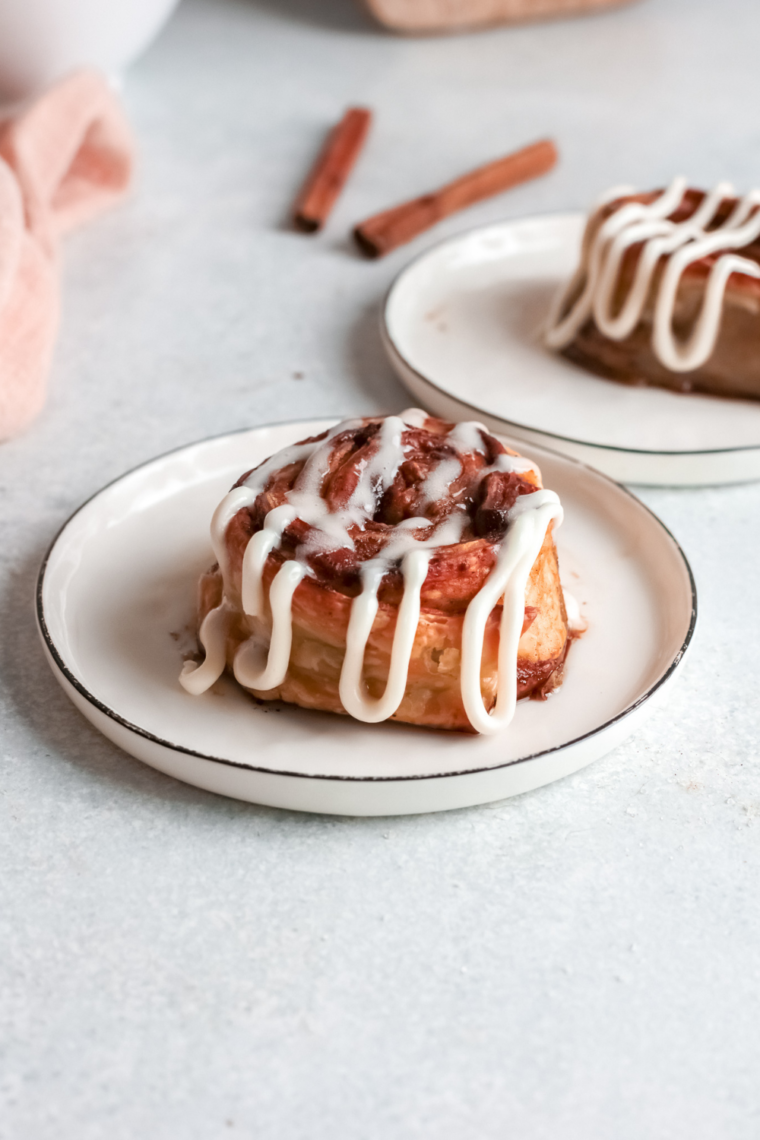 Freshly air-fried pumpkin cinnamon rolls with glaze on a serving plate.