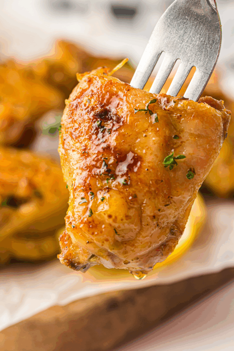 Crispy and juicy air fryer honey garlic chicken thighs coated in a sticky, flavorful glaze, served on a plate with garnish.