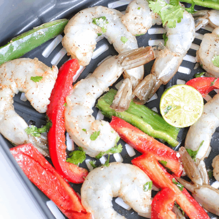 Pesto-coated shrimp arranged in a single layer in the air fryer basket