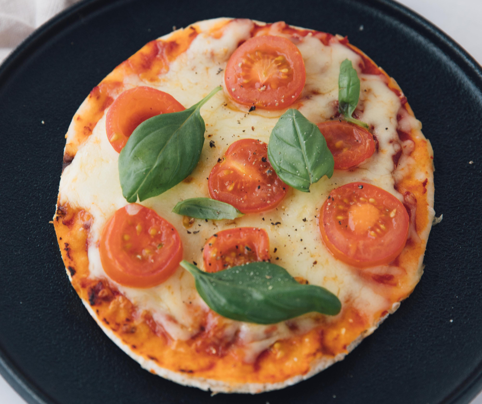 Homemade Panera Margherita Flatbread Pizza topped with tomatoes, mozzarella, and basil on a wooden board