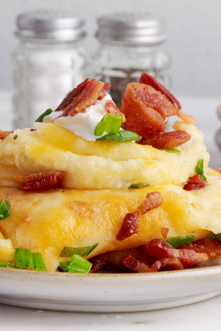 Creamy mashed potatoes topped with melted butter made in the air fryer, smooth fluffy texture served in a bowl.