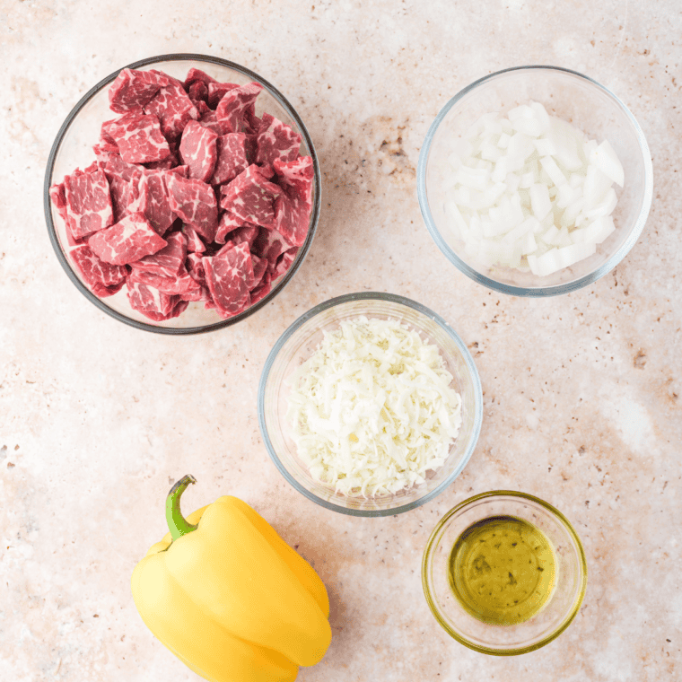 Ingredients needed for Air Fryer Philly Cheesesteak Stuffed Peppers on kitchen table.