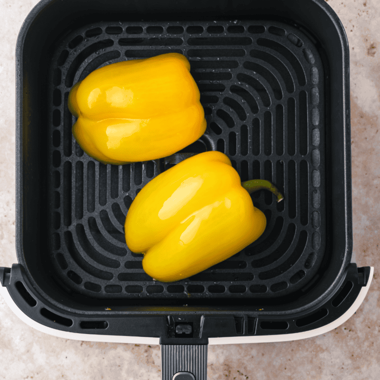 Preparing bell peppers with olive oil, air frying at 400°F for 5 minutes, flipping halfway.