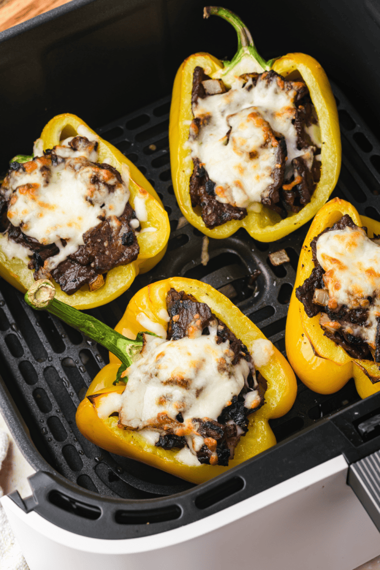 Air Fryer Philly Cheesesteak Stuffed Peppers with steak, onions, and melted cheese inside roasted bell peppers.
