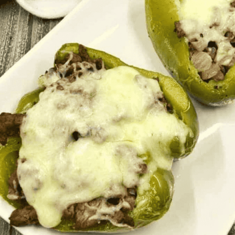 Air Fryer Philly Cheesesteak Stuffed Peppers with steak, onions, and melted cheese inside roasted bell peppers.