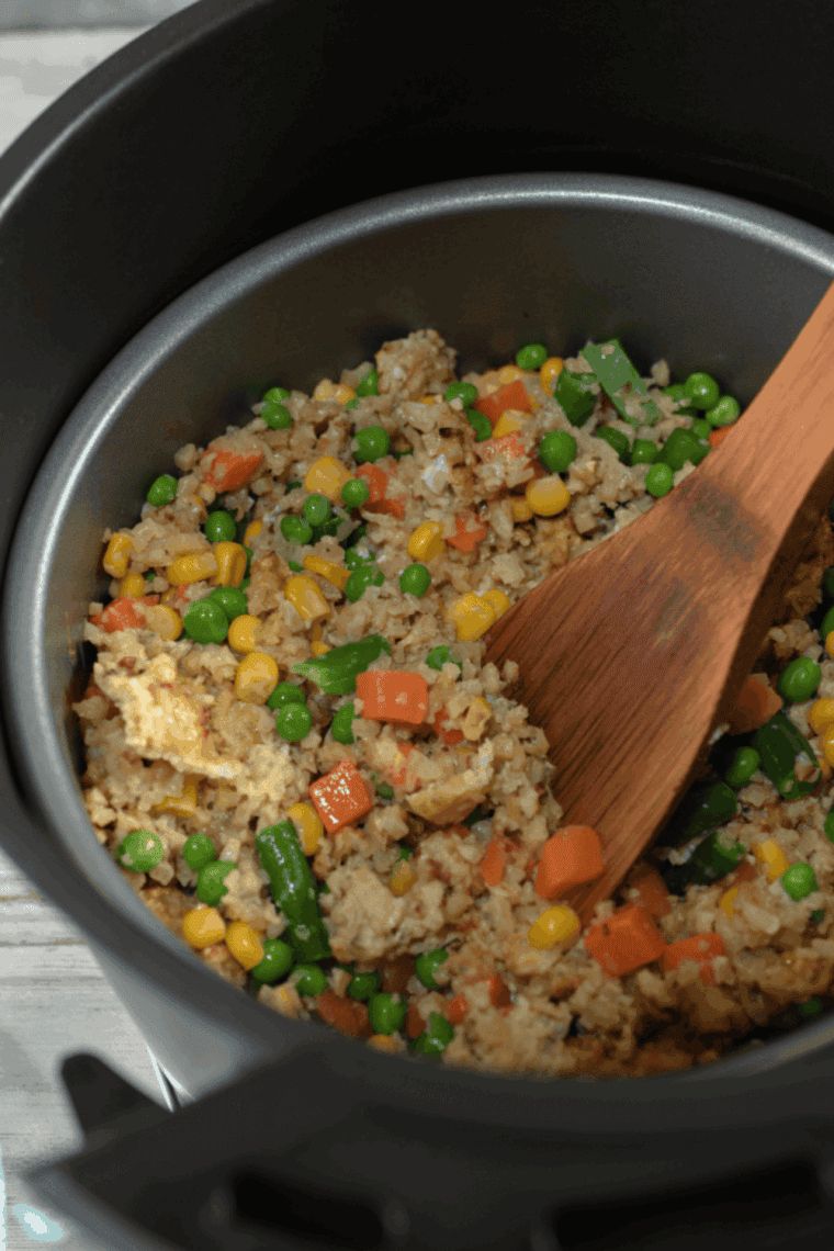 Benihana-style garlic chicken cauliflower fried rice served on a plate with colorful vegetables and green onions.