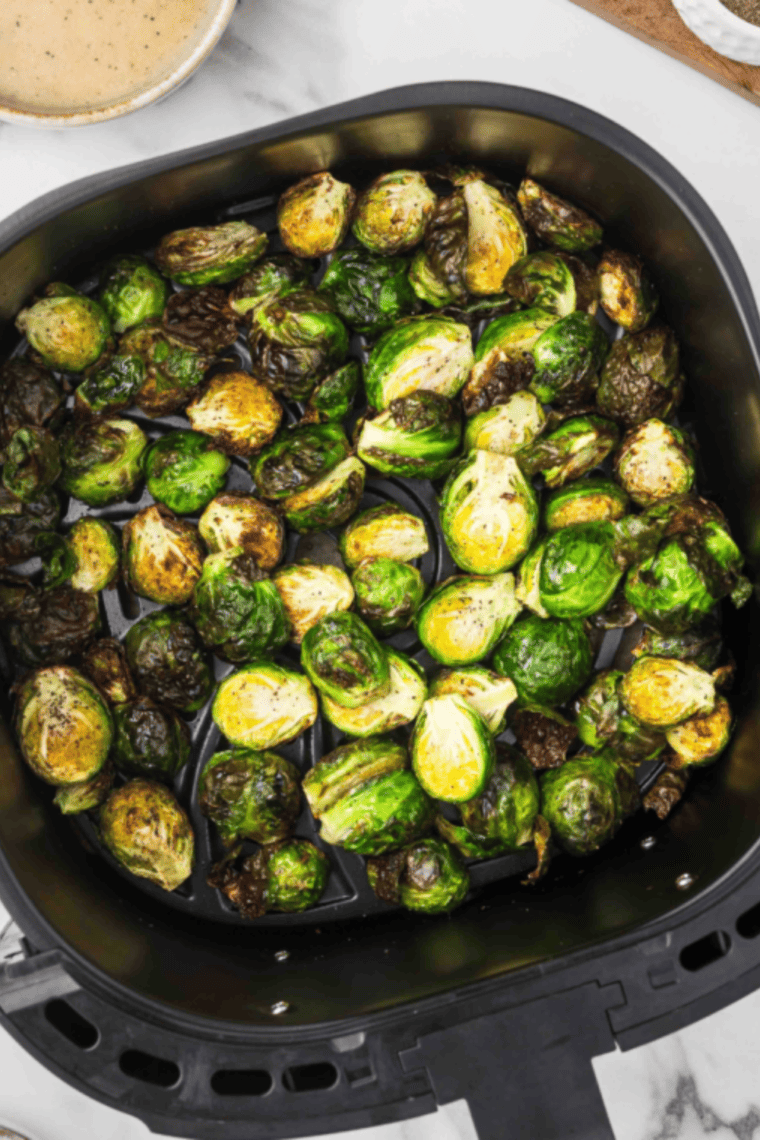 Golden, crispy air fryer Brussels sprouts fresh from the basket, ready to toss in glaze
