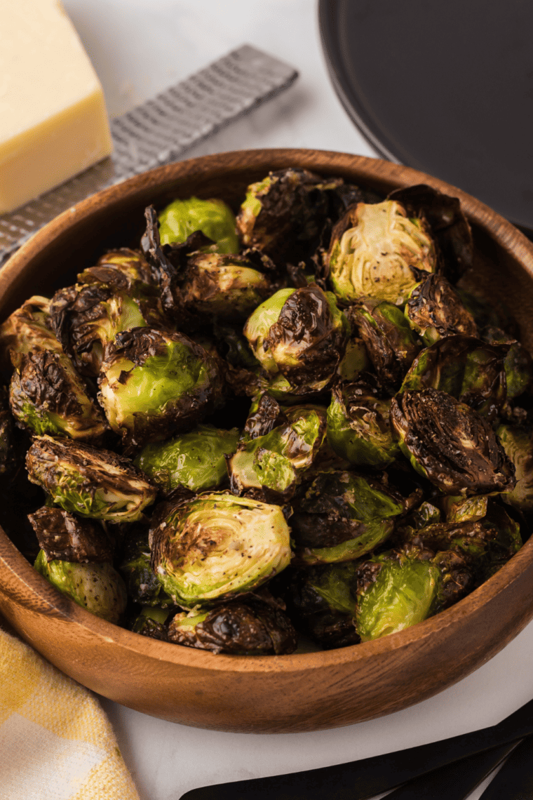 Crispy Brussels sprouts in a smoky-sweet glaze with red pepper flakes, served in a white bowl