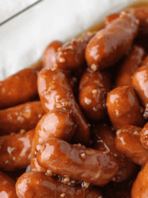 Air fryer little smokies coated in a glossy grape jelly sauce, served in a dish with toothpicks