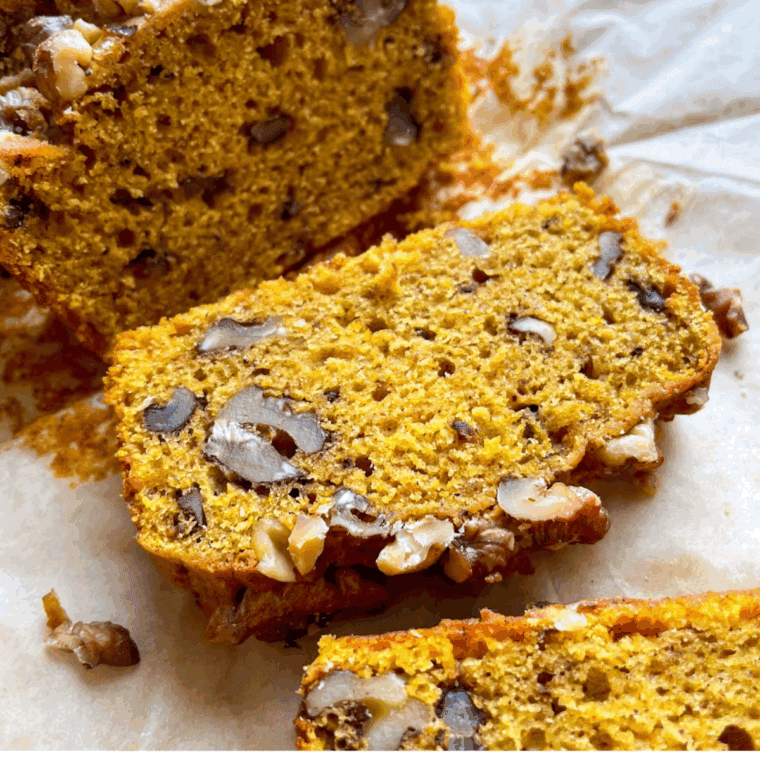 A sliced loaf of moist Bob Evans style pumpkin bread with warm spices, displayed on a rustic wooden cutting board.