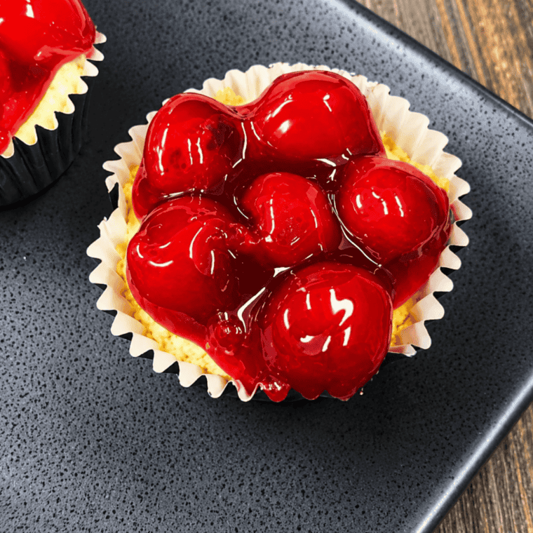 Air fryer cherry cheesecake cupcakes topped with cherry pie filling after chilling
